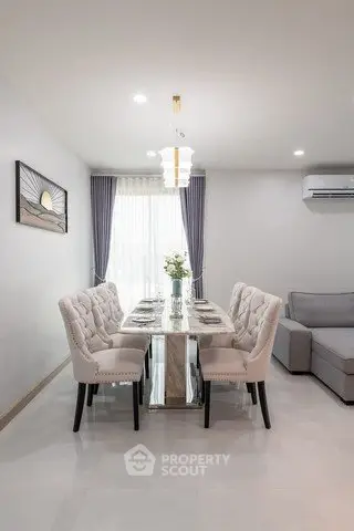 Elegant dining area with plush chairs and modern decor in a bright, airy living space.