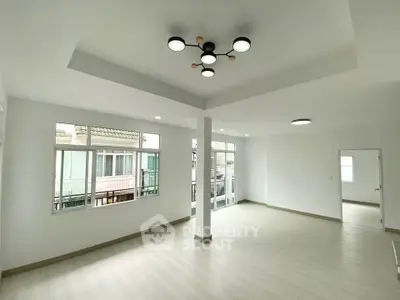 Spacious modern living room with large windows and stylish ceiling lights
