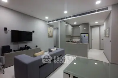 Modern open-plan living room and kitchen with sleek design and neutral tones.