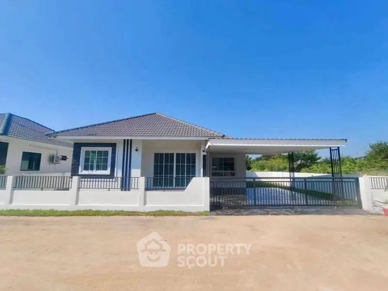 Charming single-story house with spacious driveway and modern design under clear blue sky.