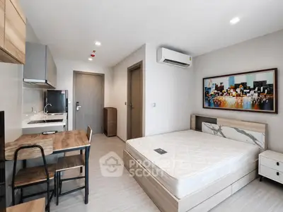 Modern studio apartment with stylish decor and compact kitchen area.