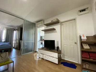 Modern apartment interior with open layout, featuring a cozy living area and a glimpse of the bedroom.