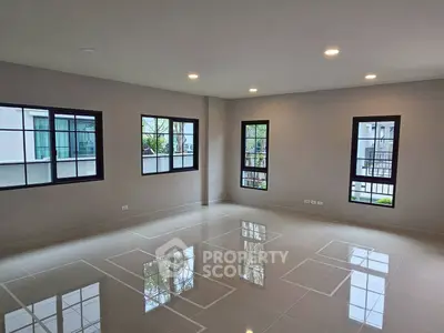 Spacious modern living room with large windows and glossy tiled floors