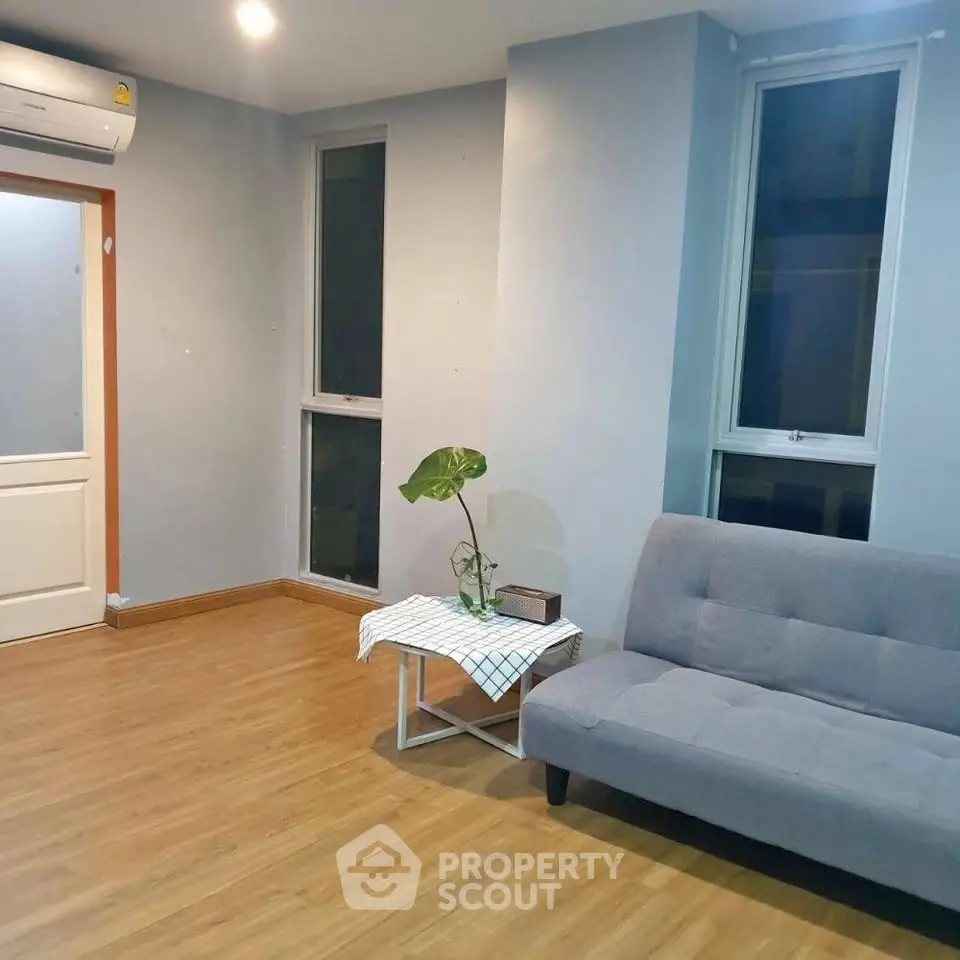 Modern living room with stylish sofa and wooden flooring in a cozy apartment.