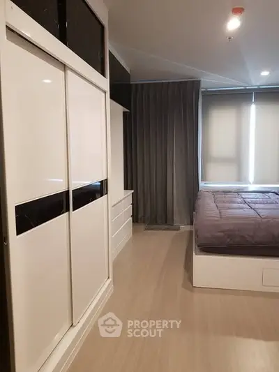Modern bedroom with sleek wardrobe and cozy bed in stylish apartment.