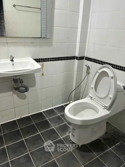 Modern bathroom with sleek white tiles and contemporary fixtures.