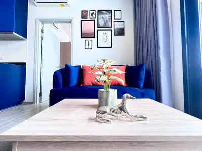 Modern living room with blue sofa, stylish decor, and natural light