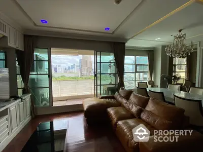 Luxurious spacious living room with leather sofas, polished hardwood floors, and an expansive city view from the floor-to-ceiling windows, complemented by elegant drapery and a classic chandelier.