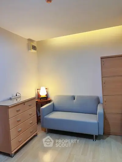 Cozy living room with modern sofa and wooden furniture, perfect for relaxation.