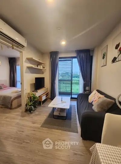 Modern living room with cozy decor and balcony view in stylish apartment.