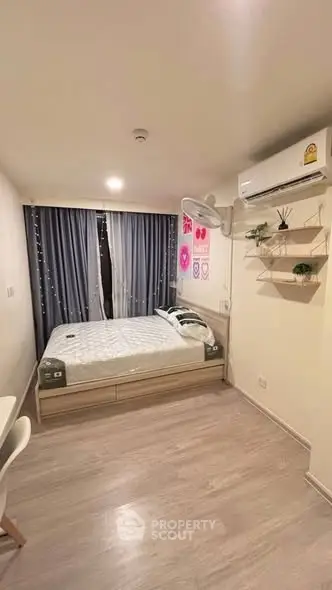 Cozy bedroom with modern decor, featuring a comfortable bed, air conditioning, and stylish shelving.