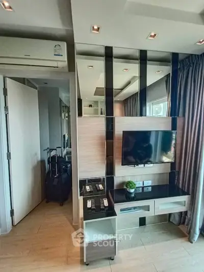 Modern living room with sleek TV setup and stylish decor in a contemporary apartment.