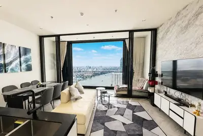 Luxurious living room with stunning city and river view, modern decor, and spacious seating area.