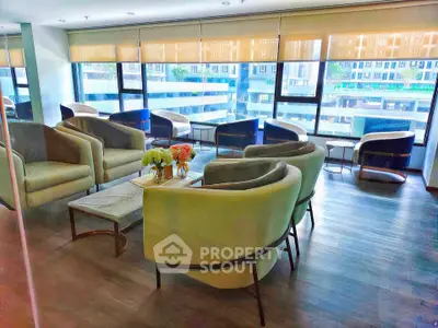 Spacious modern living room with large windows and stylish seating, offering a bright and inviting atmosphere.