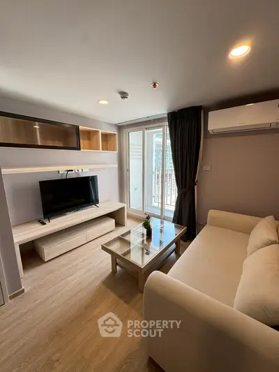 Modern living room with cozy sofa, TV unit, and balcony view in stylish apartment.