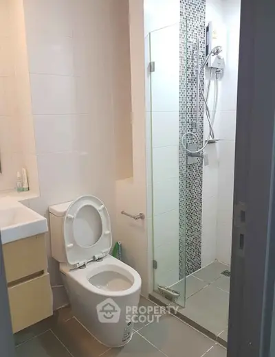 Modern bathroom with glass shower and sleek fixtures in a contemporary home.