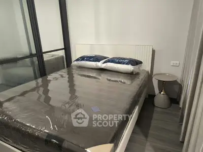 Modern bedroom with sleek design and glass partition, featuring a stylish bed and side table.