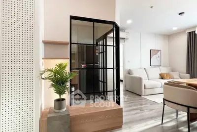 Modern living room with stylish decor and glass partition, featuring cozy seating and elegant flooring.