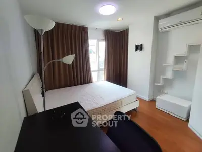 Modern bedroom with natural light, wooden flooring, and air conditioning.