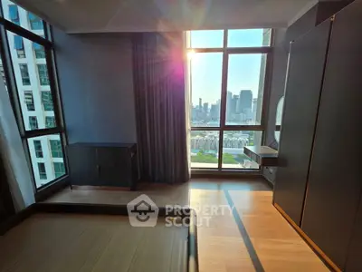 Modern bedroom with stunning city view and large windows, featuring sleek furniture and wooden flooring.