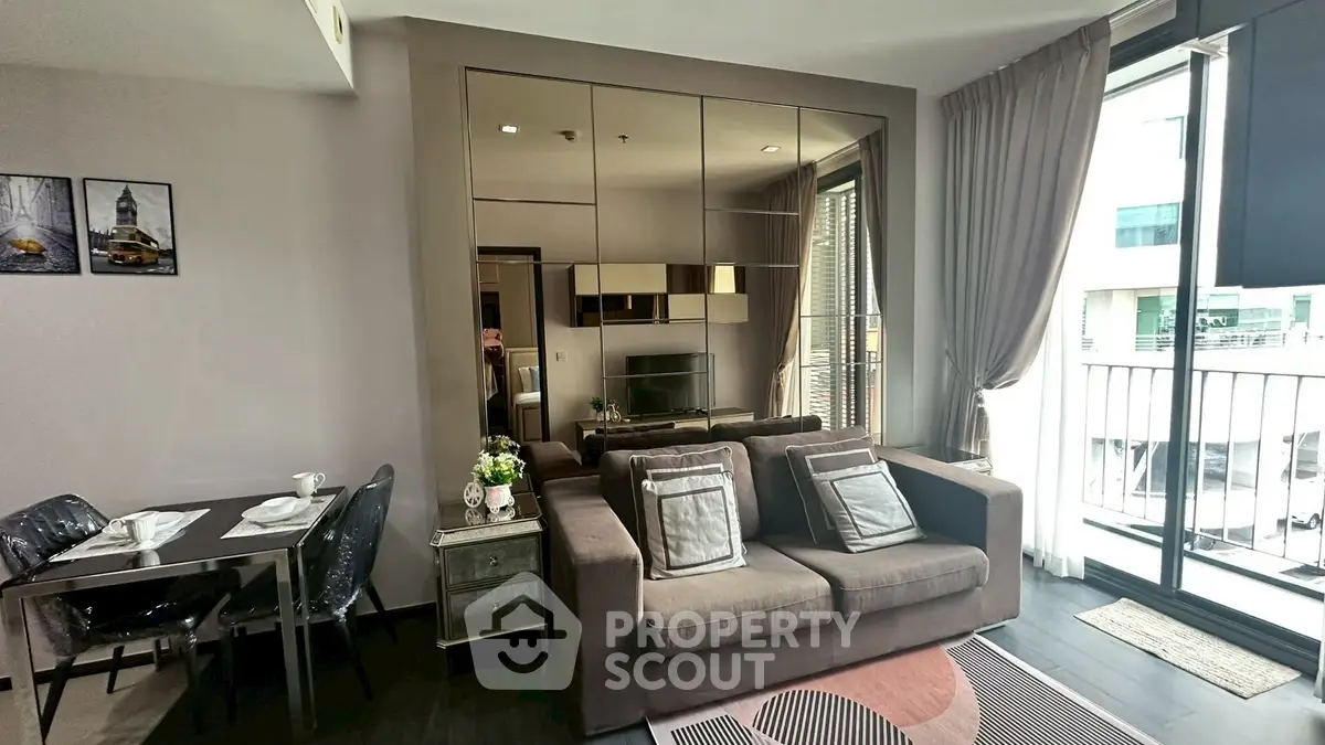 Modern living room with stylish decor and balcony view in urban apartment.