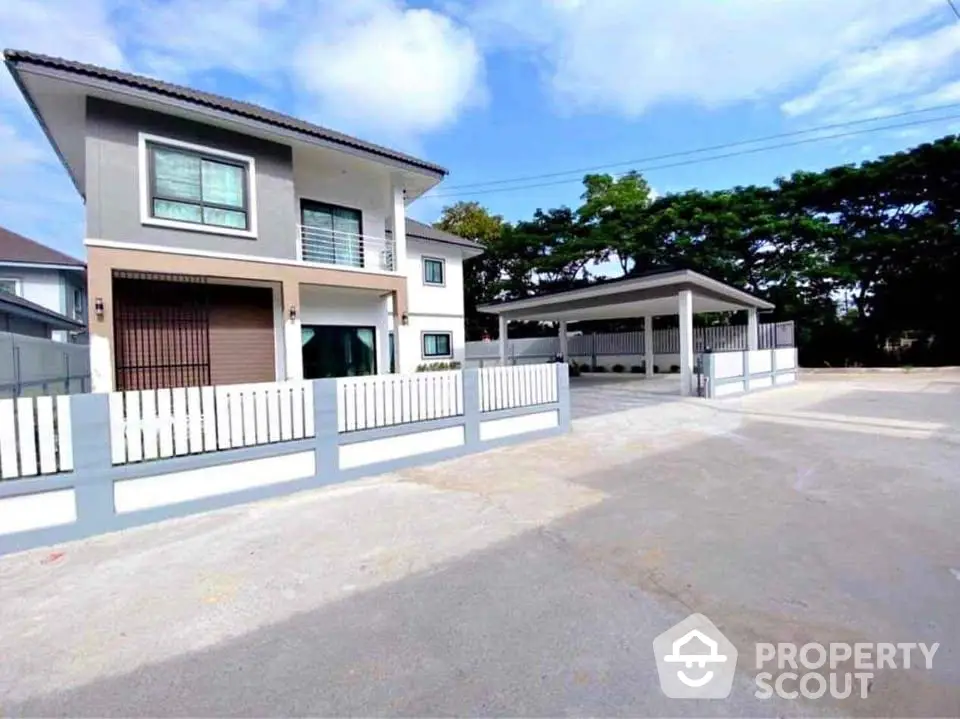 Modern two-story house with spacious driveway and carport in suburban setting