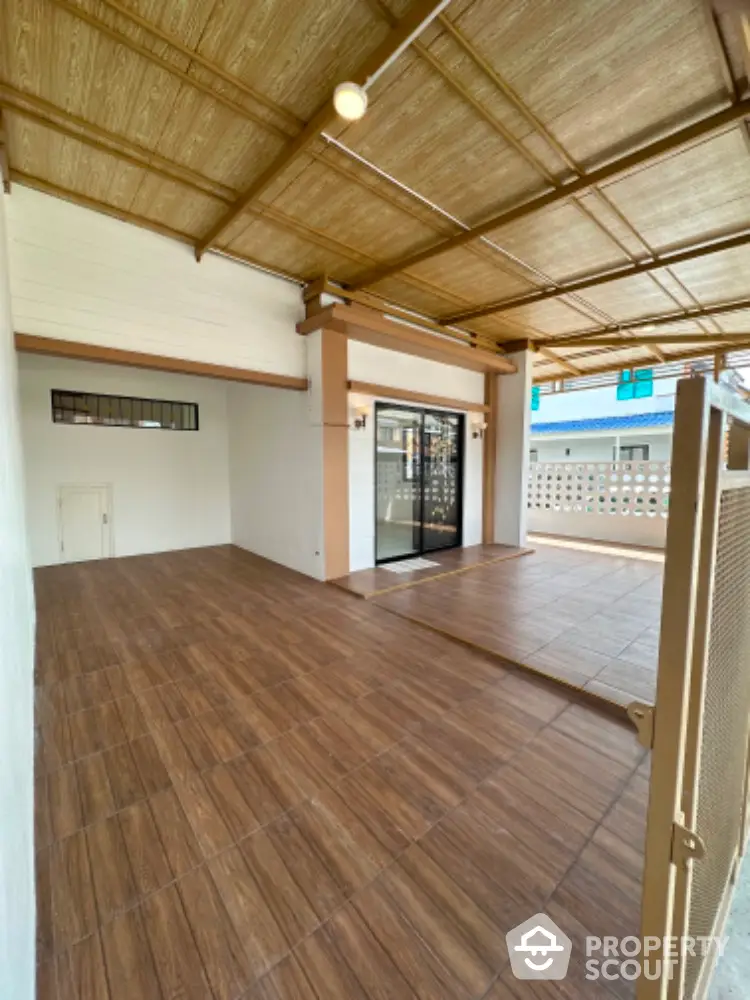 Spacious covered balcony with modern tiles and sliding glass doors