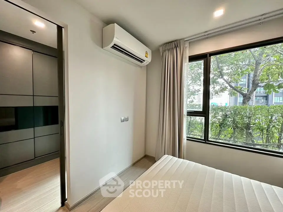 Modern bedroom with large window and air conditioning in a stylish apartment.