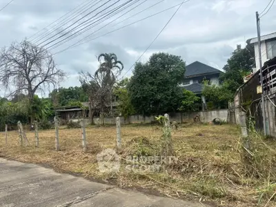 Vacant land plot with potential for development in a residential area, surrounded by greenery and neighboring houses.
