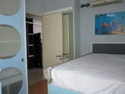 Modern bedroom with blue accents and wall art, featuring a comfortable bed and sleek design.