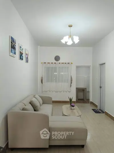 Cozy living room with modern beige sofa and elegant decor, perfect for relaxation and entertaining.