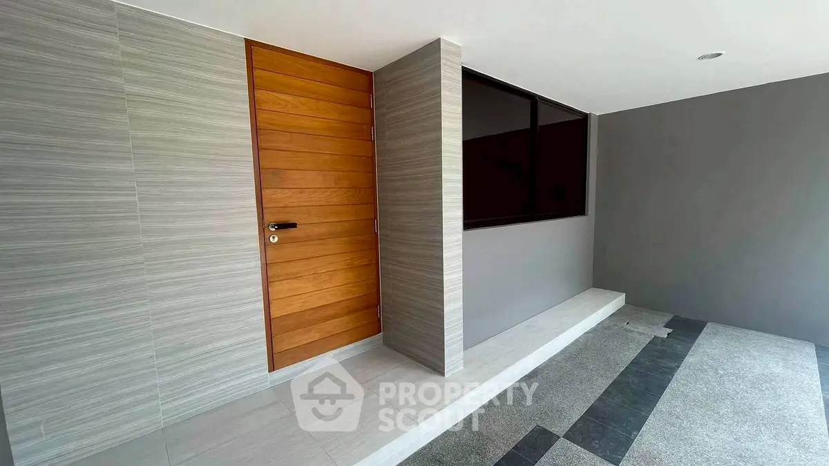 Modern entrance with sleek wooden door and minimalist design