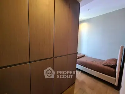 Cozy bedroom with wooden wardrobe and single bed, perfect for minimalist living.