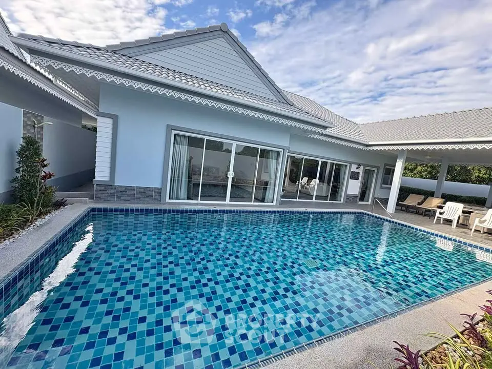 Stunning property with a sparkling pool and modern architecture under a clear blue sky.