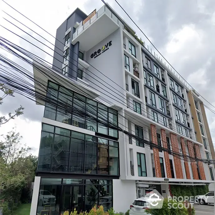 Modern urban apartment building with stylish facade, large glass windows, and lush green surroundings, ideal for city living.