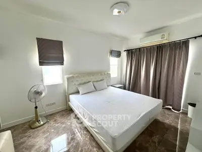 Spacious bedroom with elegant decor and natural light, featuring a comfortable bed and modern furnishings.