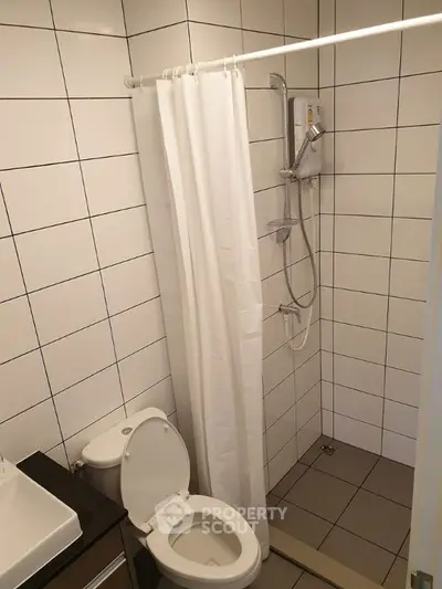 Modern bathroom with shower and toilet in a tiled setting