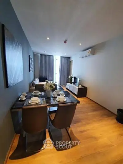 Modern living room with dining area, stylish decor, and wooden flooring in a cozy apartment.