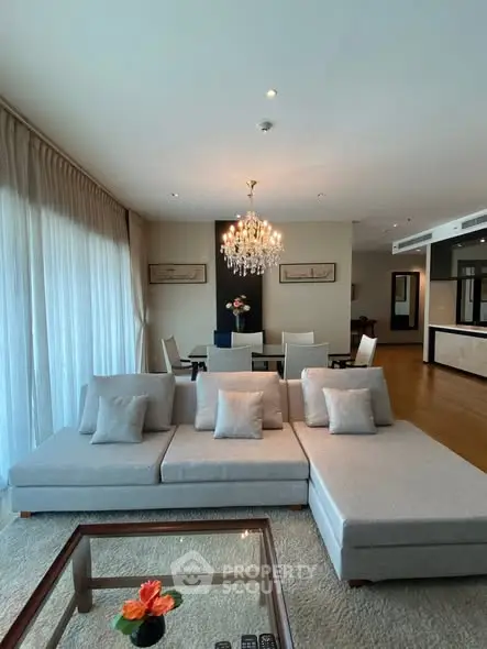 Luxurious living room with elegant chandelier and modern furniture in a spacious open layout.
