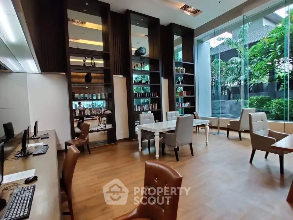 Spacious modern library with floor-to-ceiling windows and elegant seating in a luxury building.
