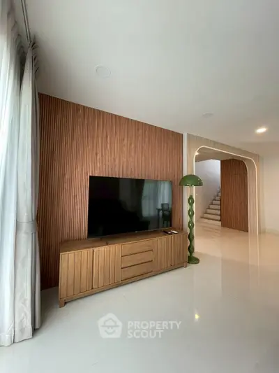 Modern living room with sleek TV setup and stylish wooden paneling