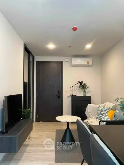 Modern living room with sleek furniture and stylish decor, featuring a wall-mounted TV and cozy seating area.