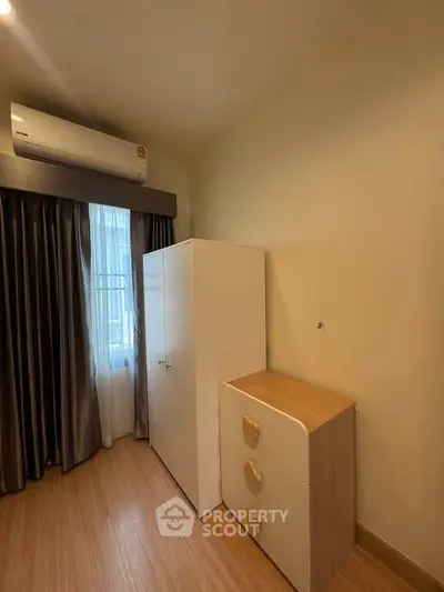 Cozy bedroom with air conditioning and stylish furniture in modern apartment.