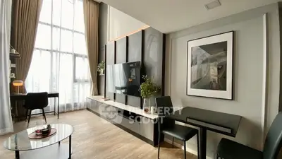 Modern living room with high ceilings, elegant decor, and large windows for natural light.