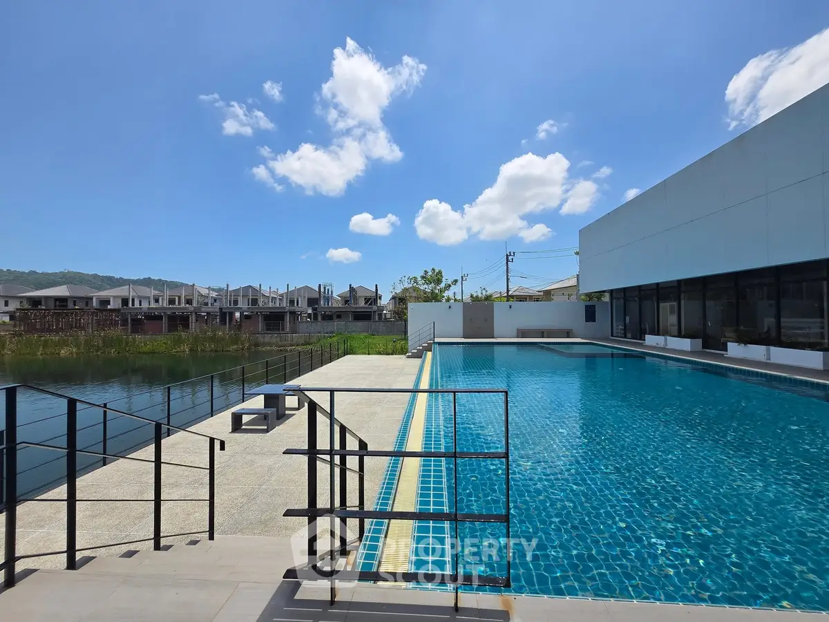 Luxurious modern swimming pool with clear blue water and sunny sky, perfect for relaxation and leisure.