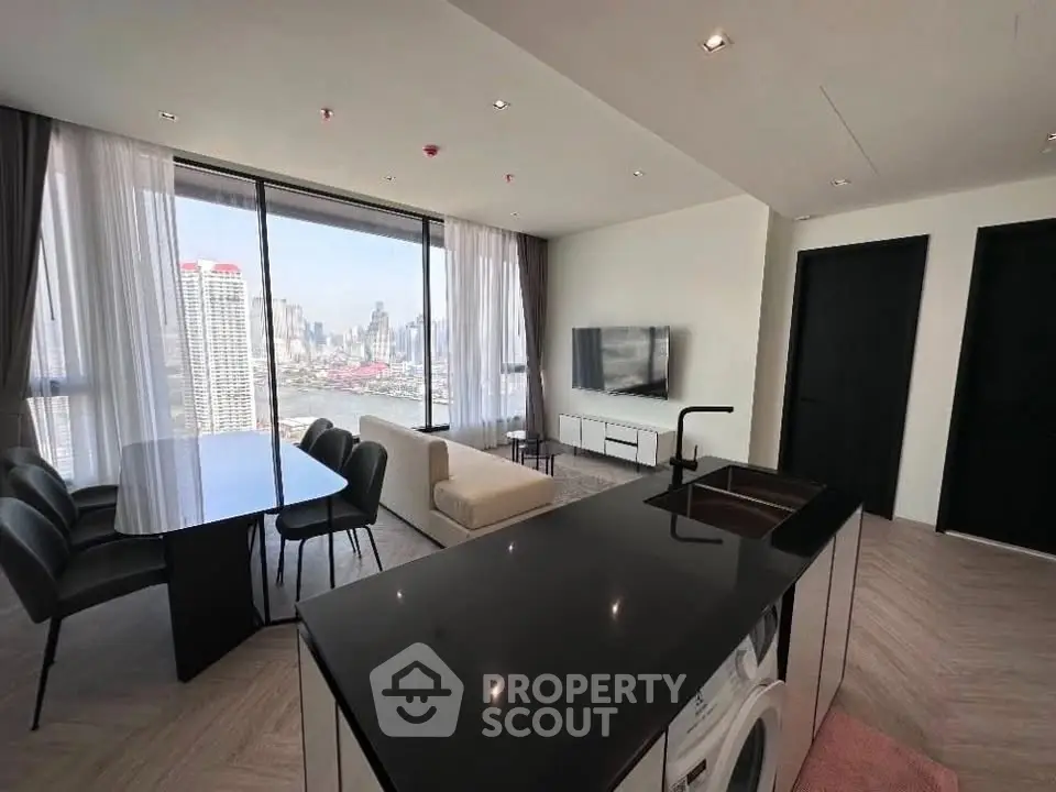 Luxurious high-rise living room with stunning city view and modern open kitchen.