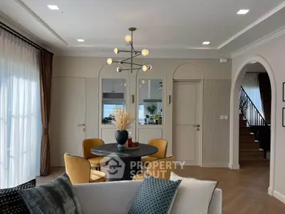 Elegant living room with modern chandelier and cozy seating area, perfect for relaxation and entertaining.