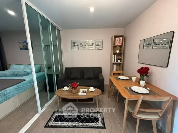 Modern living room with cozy seating and dining area, featuring elegant decor and natural light.