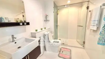 Modern bathroom with glass shower, sleek fixtures, and elegant decor in a contemporary home.