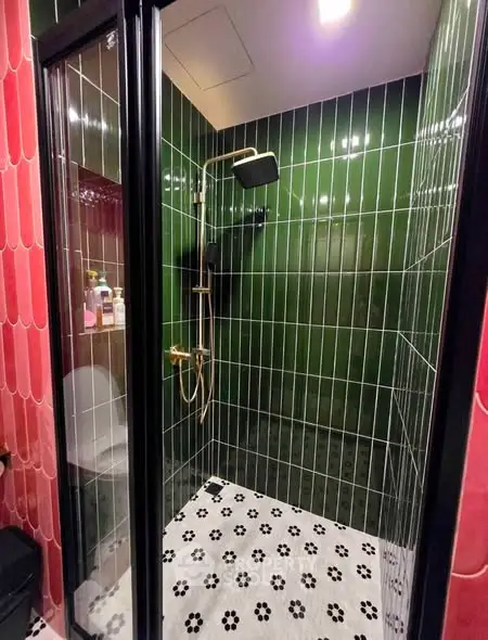 Stylish modern bathroom with green tiles and glass shower enclosure